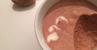 mousse au chocolat servie dans une tasse avec une cuillère