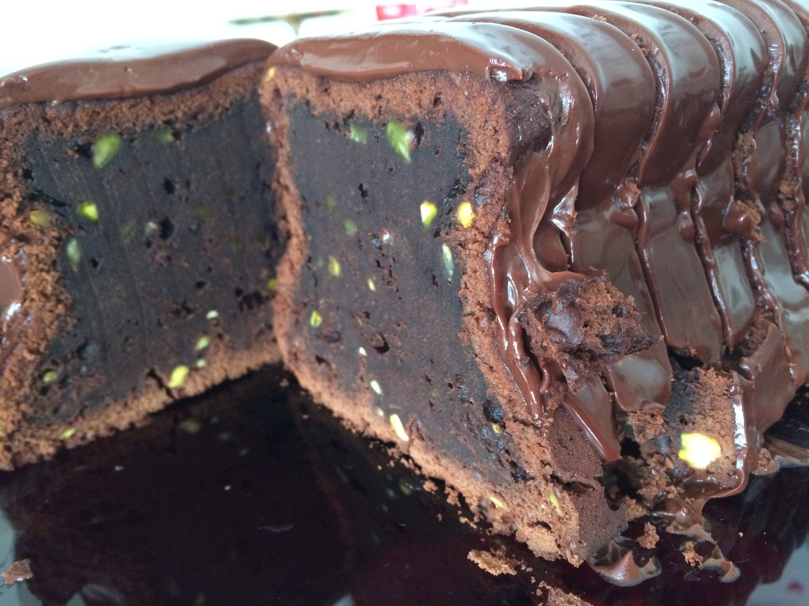 part de cake au chocolat avec des inclusions de pistache