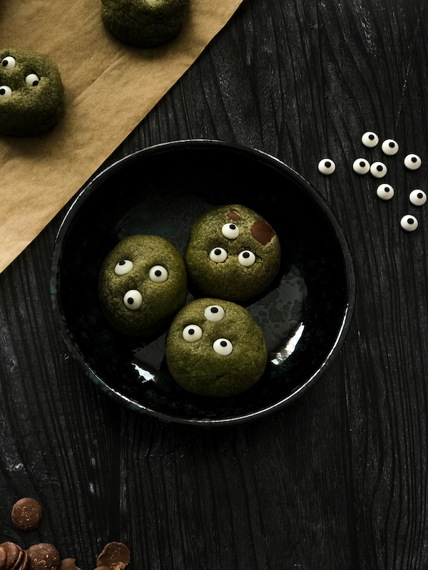 assiette remplie de cookies verts au thé matcha avec des yeux en sucre